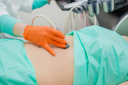 女医生用超声波扫描仪检查病人的胃。
