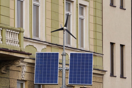 街道上的电力由小型风车和太阳能电池板在城市的建筑物在白天.