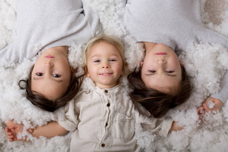 Beautiful portrait of three sibling boys, lying on the floor in 