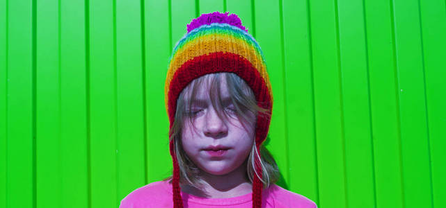 女孩彩虹针织帽子绿色背景