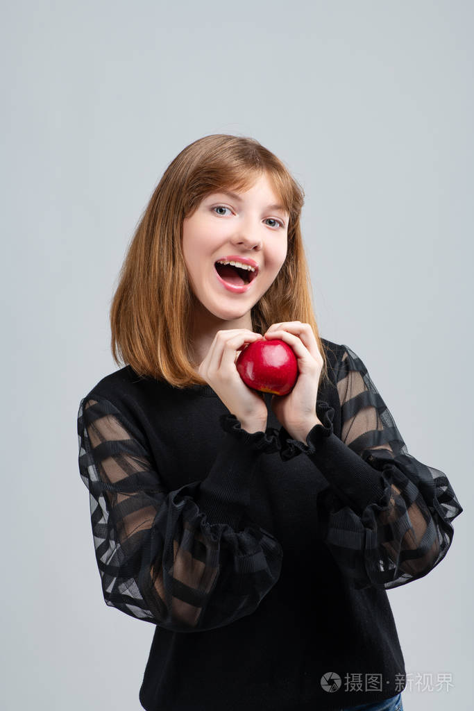女孩手拿苹果在镜头前摆姿势