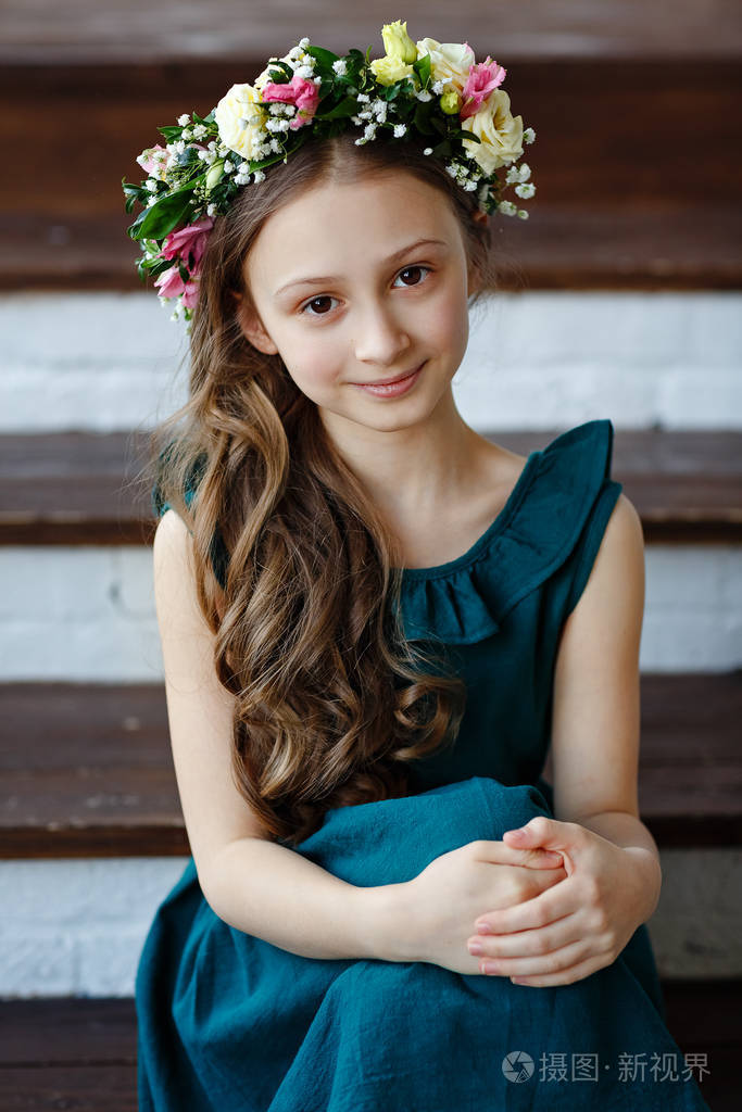 漂亮可爱的小女孩,长发,绿色连衣裙,头戴鲜花花环,微笑着看着镜头