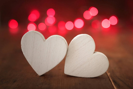 情人节概念。两颗心在木制背景和闪光灯上