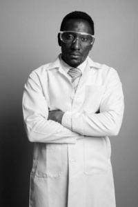 年轻英俊的非洲男子医生戴着灰色背景的护目镜