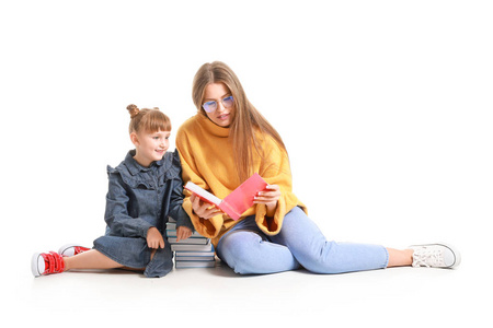 美丽的年轻女子和她的小女儿在白色背景上看书