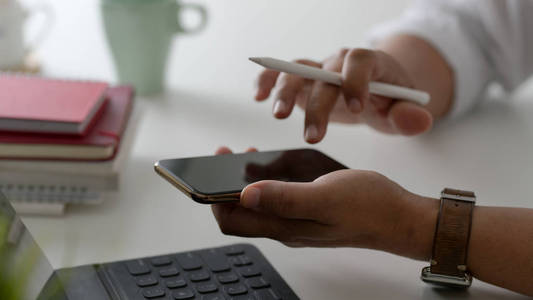 Side view of businessman typing on his smartphone in modern work