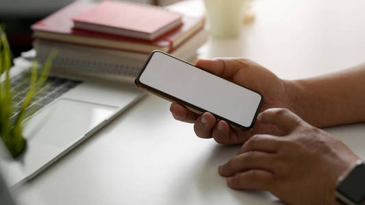 Side view of businessman using blank screen smartphone in modern