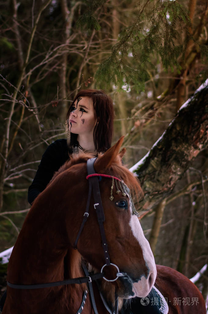 一个北欧海盗女孩骑着一匹涂有黑色符文的红马