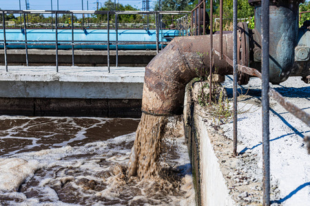 水从自来水泉流出来,公园里的人喝水脏污水从破裂的管道进入地面排出