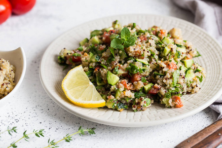 Quinoa salad with fresh tomatoes, cucumbers and salad leaves. 