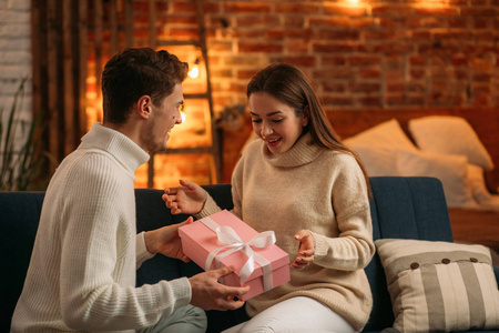 帅哥送礼物给漂亮的女朋友,面带微笑.