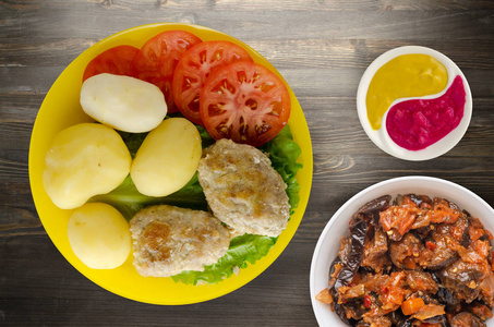 Cutlets with potatoes and stewed tomatoes.  