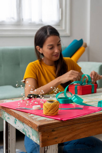 妇女在家里把手工制作的礼品包在桌子上