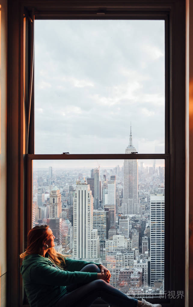 一名妇女从曼哈顿高楼的窗户望出去的照片
