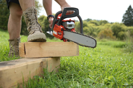  hands of a man holding a chainsaw.