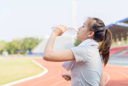 Beautiful asian athlete woman drinking water from bottle 