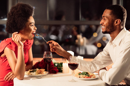 一对幸福的情侣在餐厅互相喂食庆祝情人节