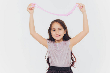 小女孩在玩黏液.孤立的白色背景.摄影图