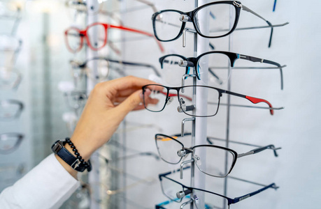 Stand with glasses in the store of optics. Eyesight correction. 