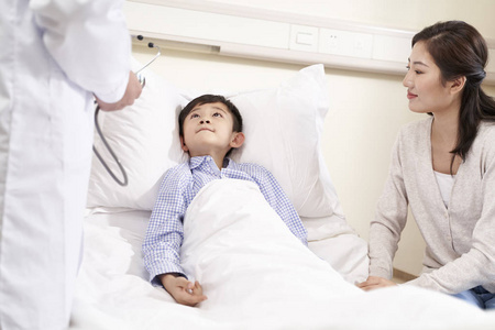 五岁亚洲小孩躺在病床上陪伴图片