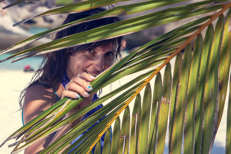 热带度假，女孩在看棕榈叶
