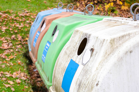 德国社区里一排白色绿色五颜六色的旧垃圾桶