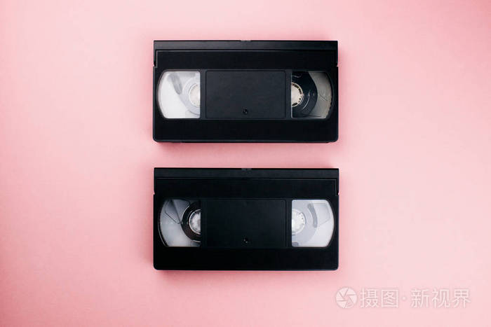 复古vhs录像带平放在彩色的粉红色背景上.俯视图复制空间.