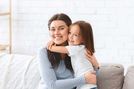 开心的母亲和小女儿在家里拥抱的画像