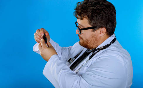 戴眼镜的医生举着瓶子检查药物。
