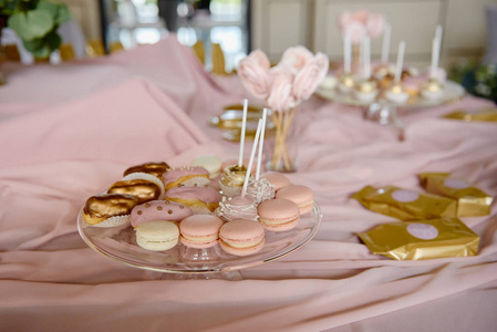 在餐厅提供糖果棒和杏仁饼松糕糕点和糕点。餐后甜点桌颜色为粉色。