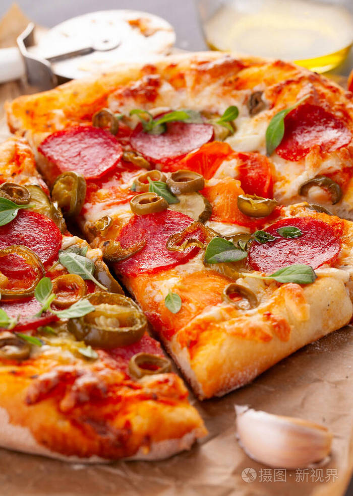 自制辣味香肠披萨和烹饪原料灰色木桌上的意大利香肠披萨