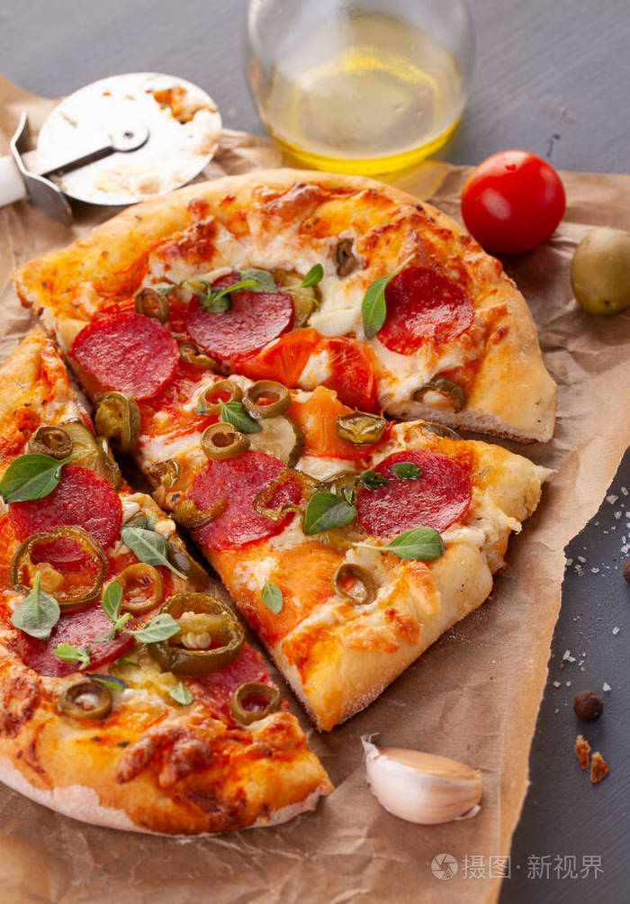 自制辣味香肠披萨和烹饪原料灰色木桌上的意大利香肠披萨
