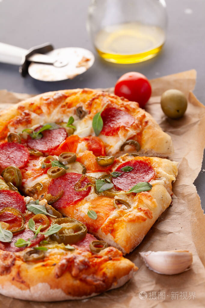 自制辣味香肠披萨和烹饪原料灰色木桌上的意大利香肠披萨