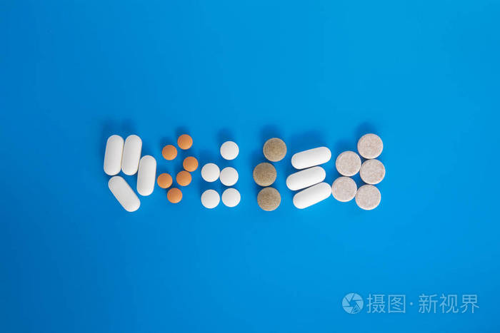 药物蓝色背景的不同药丸和胶囊