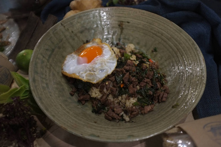 Rice topped with stirfried beef and basil and fried egg , Conce