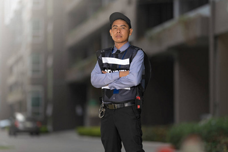 Security man standing outdoors near big building 