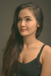 灰色背景下年轻美丽的亚洲女人