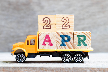 木制背景上word 22apr的卡车货舱字母块概念日期为4月22日
