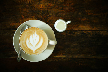 咖啡杯卡布奇诺拿铁艺术在木制背景上