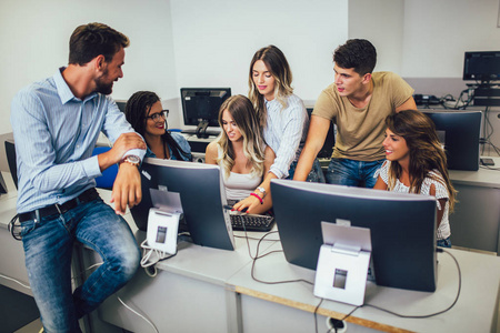 College students sitting in a classroom, using computers during 