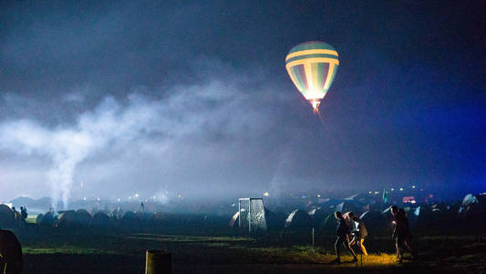 热气球在天空下壮观的卡帕多西亚上空飞行，夜晚有银河和星星带谷物