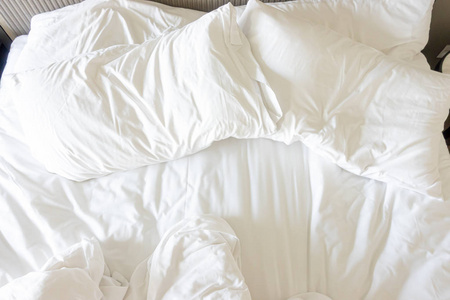 床上铺着毯子的白色枕头