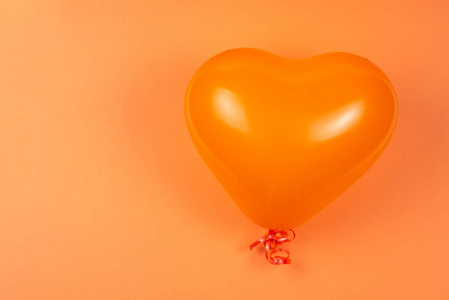 Orange heart ballon on orange background. 