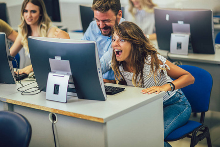 College students sitting in a classroom, using computers during 