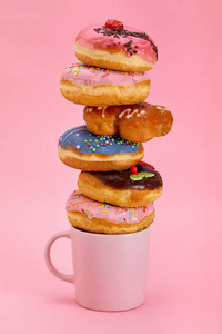 彩色甜甜圈早餐组合，不同颜色的甜甜圈和新鲜咖啡粉背景
