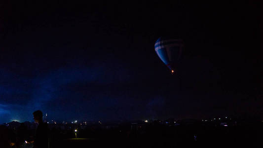 热气球在天空下壮观的卡帕多西亚上空飞行，夜晚有银河和星星带谷物