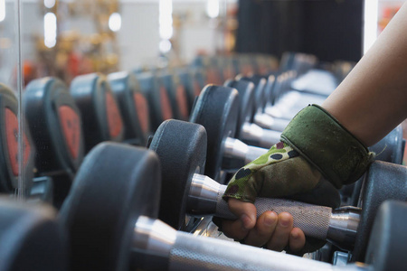 近距离手拿哑铃练习力量训练照片