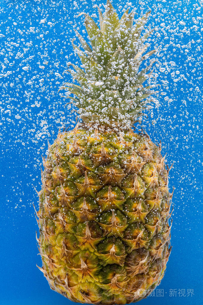 水下的菠萝被泡沫覆盖背景是蓝色的