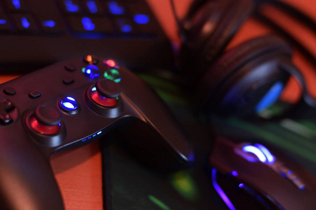 现代游戏板和游戏鼠标与键盘和耳机躺在桌上黑暗的游戏室场景。职业网络体育竞赛的现代电子技术