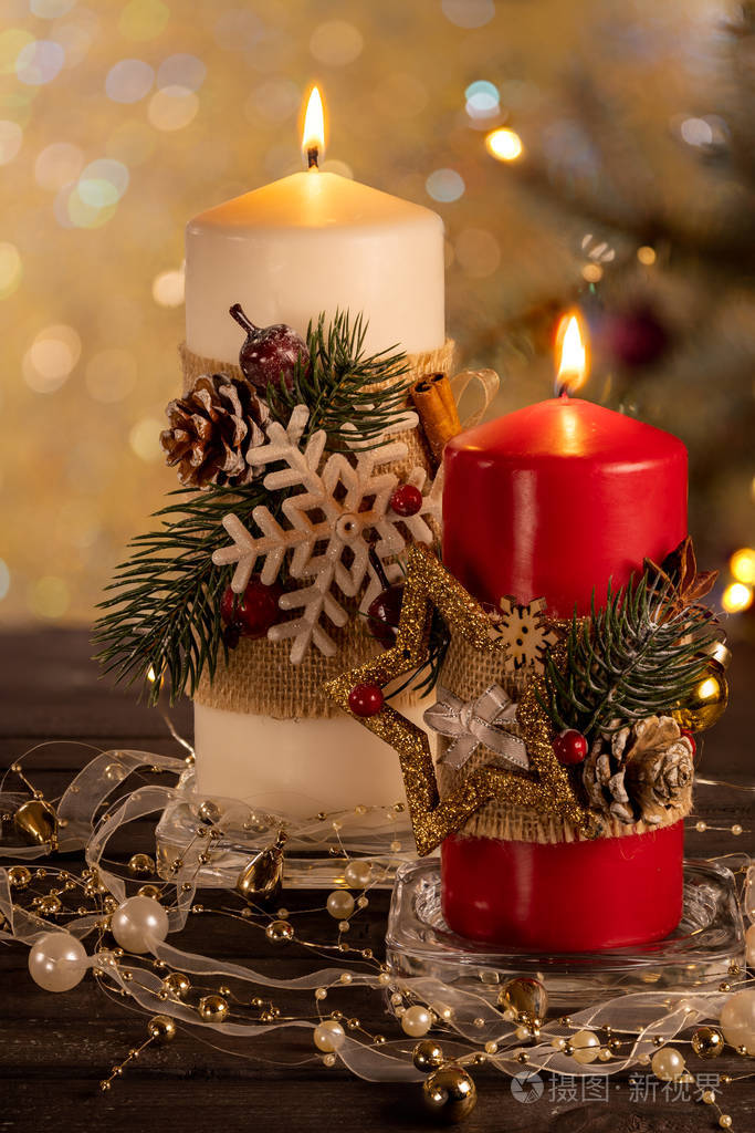 圣诞树的背景上有两支红白相间的圣诞蜡烛